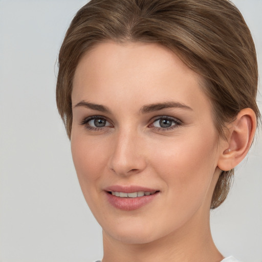 Joyful white young-adult female with medium  brown hair and grey eyes