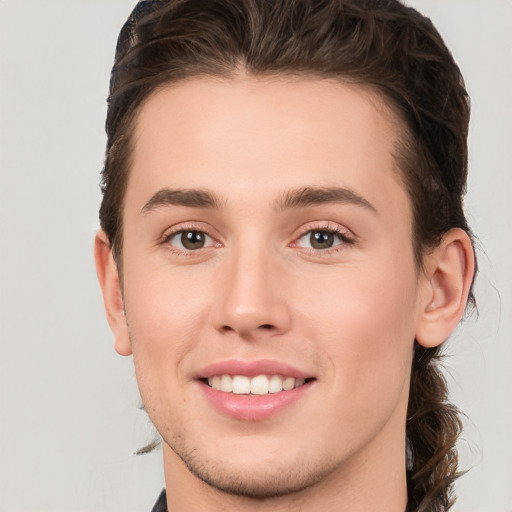 Joyful white young-adult male with short  brown hair and green eyes