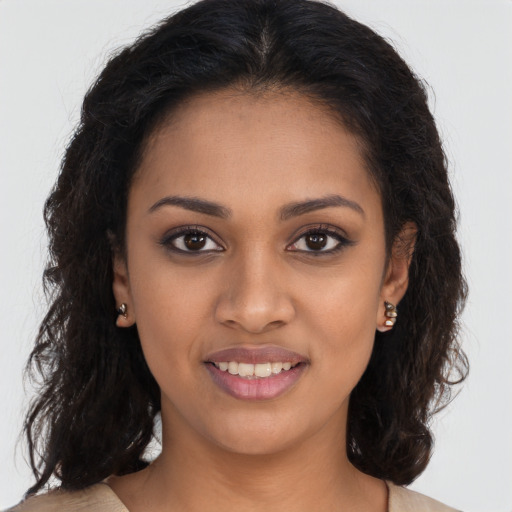 Joyful black young-adult female with long  brown hair and brown eyes