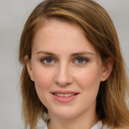 Joyful white young-adult female with medium  brown hair and blue eyes