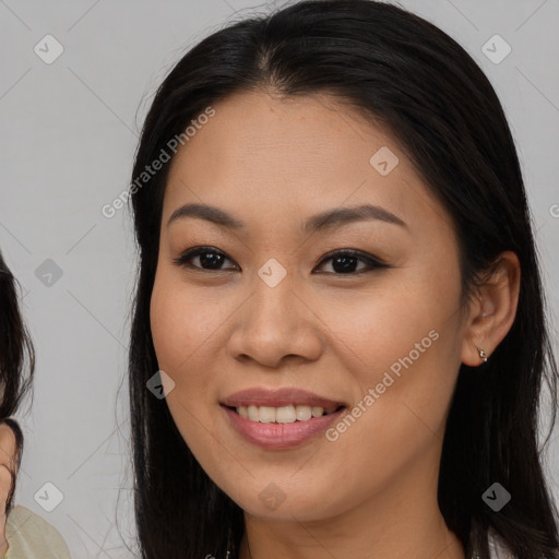 Joyful latino young-adult female with long  brown hair and brown eyes