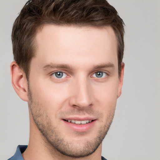 Joyful white young-adult male with short  brown hair and grey eyes