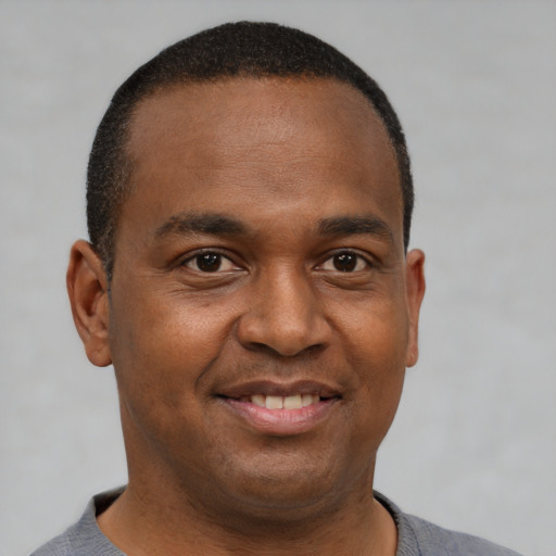 Joyful latino young-adult male with short  brown hair and brown eyes