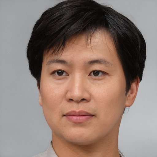Joyful asian young-adult male with short  brown hair and brown eyes