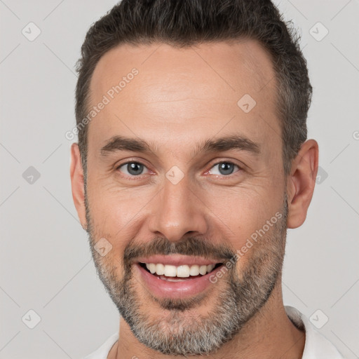 Joyful white adult male with short  brown hair and brown eyes