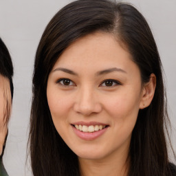 Joyful asian young-adult female with long  brown hair and brown eyes