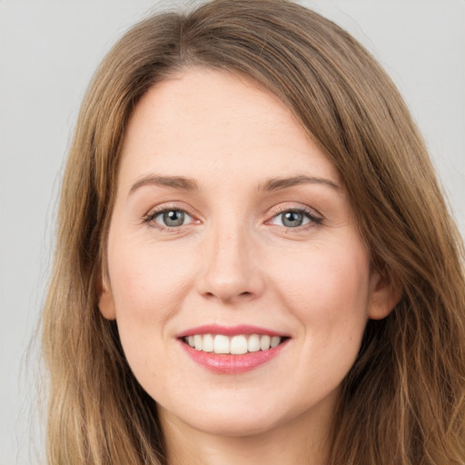 Joyful white young-adult female with long  brown hair and grey eyes