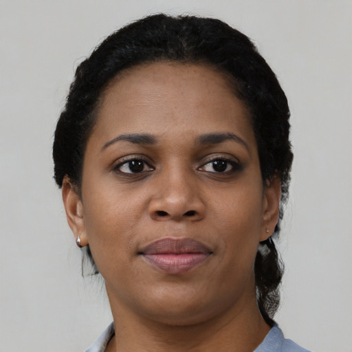 Joyful black young-adult female with short  black hair and brown eyes