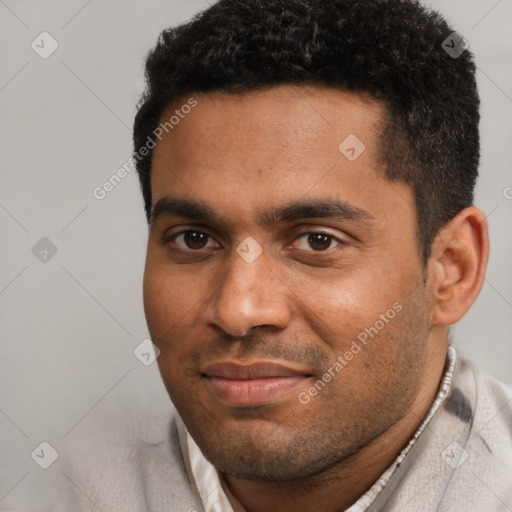 Joyful black young-adult male with short  black hair and brown eyes