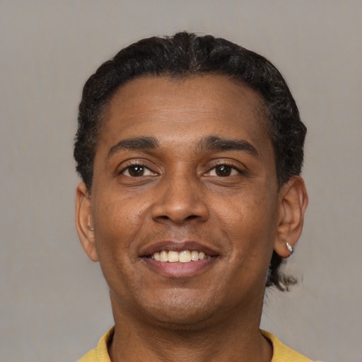 Joyful latino adult male with short  black hair and brown eyes