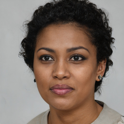 Joyful black young-adult female with short  brown hair and brown eyes