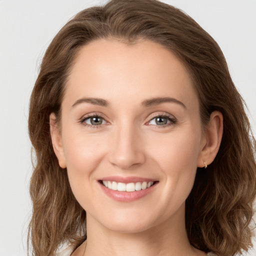 Joyful white young-adult female with long  brown hair and green eyes