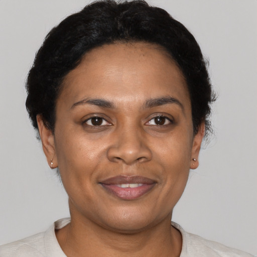 Joyful black adult female with short  black hair and brown eyes