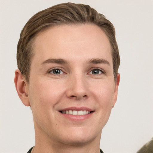 Joyful white young-adult male with short  brown hair and grey eyes