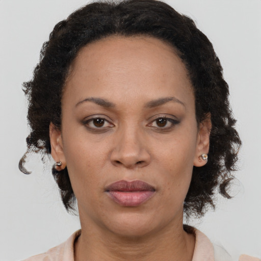 Joyful latino adult female with medium  brown hair and brown eyes