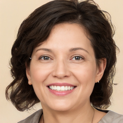 Joyful white adult female with medium  brown hair and brown eyes