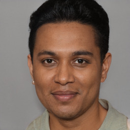 Joyful black young-adult male with short  black hair and brown eyes