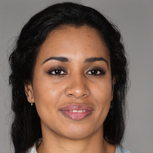 Joyful black young-adult female with long  brown hair and brown eyes