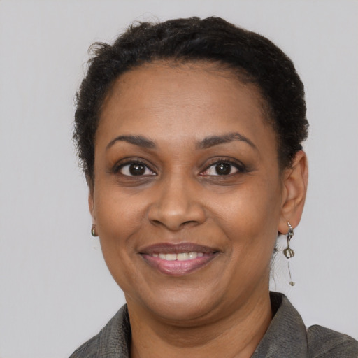 Joyful black adult female with short  brown hair and brown eyes