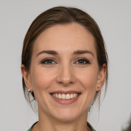 Joyful white young-adult female with medium  brown hair and grey eyes