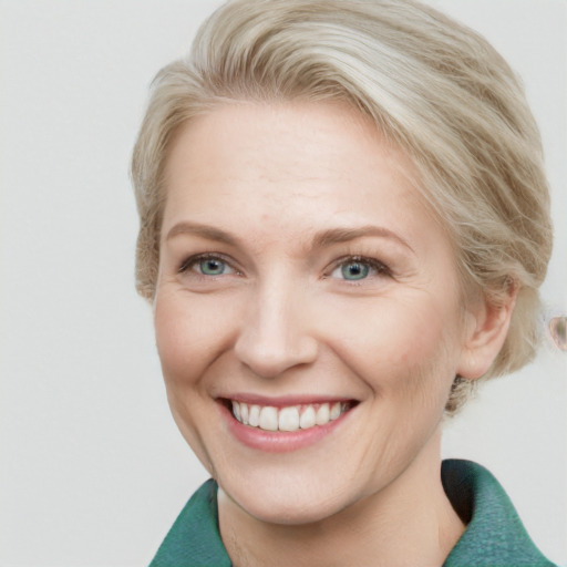 Joyful white adult female with short  brown hair and blue eyes