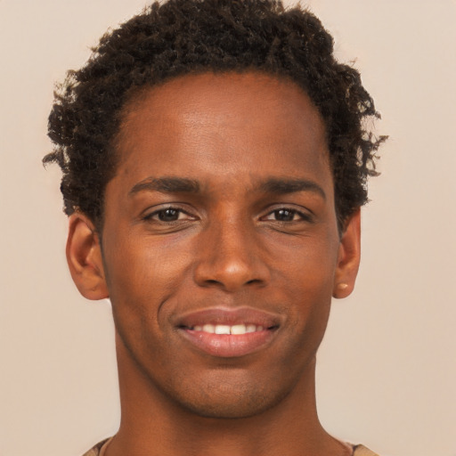 Joyful black young-adult male with short  brown hair and brown eyes