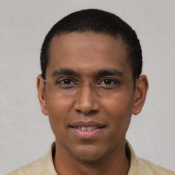 Joyful latino young-adult male with short  black hair and brown eyes