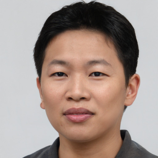 Joyful asian young-adult male with short  black hair and brown eyes