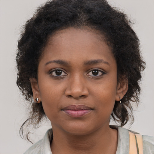 Joyful black young-adult female with medium  brown hair and brown eyes