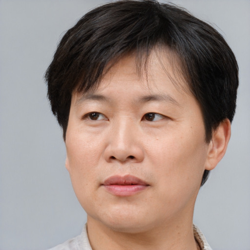 Joyful asian adult male with short  brown hair and brown eyes