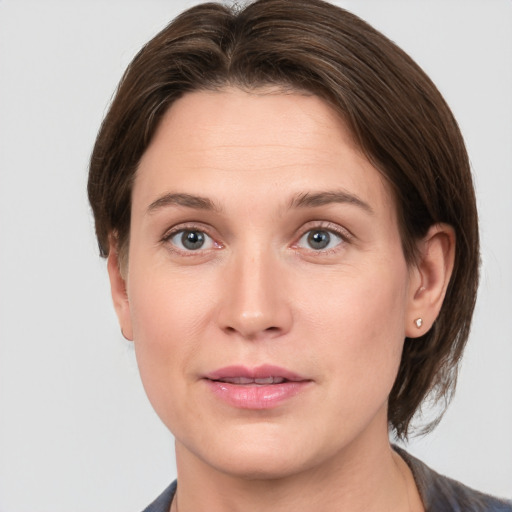 Joyful white young-adult female with short  brown hair and grey eyes