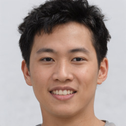 Joyful asian young-adult male with short  brown hair and brown eyes