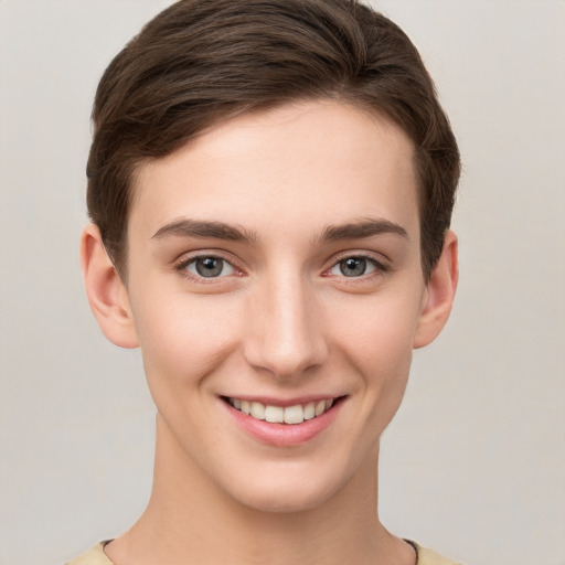 Joyful white young-adult female with short  brown hair and grey eyes