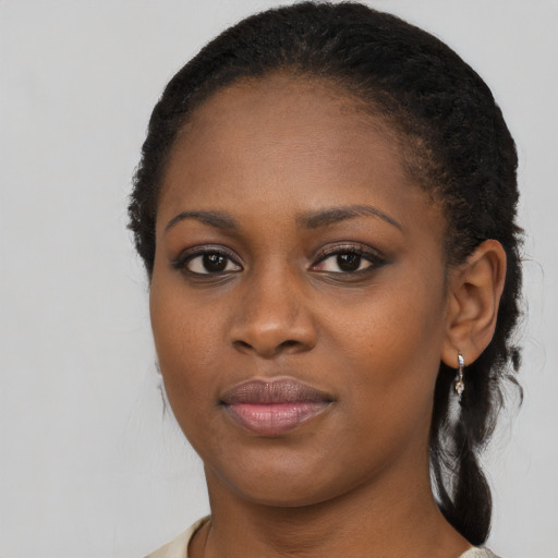 Joyful black young-adult female with long  black hair and brown eyes