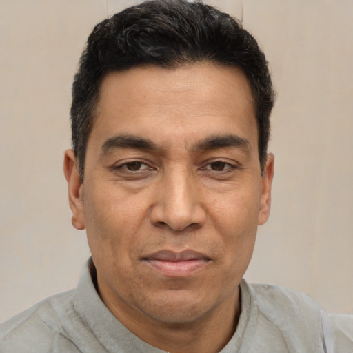 Joyful latino adult male with short  brown hair and brown eyes