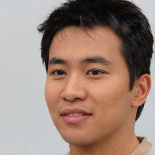 Joyful asian young-adult male with short  brown hair and brown eyes