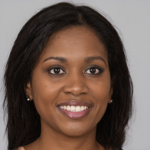 Joyful black young-adult female with long  brown hair and brown eyes
