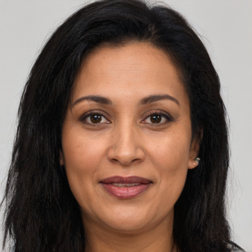 Joyful latino adult female with long  brown hair and brown eyes