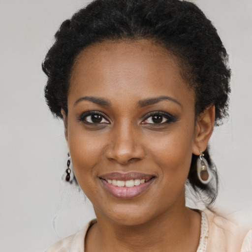 Joyful black young-adult female with long  black hair and brown eyes