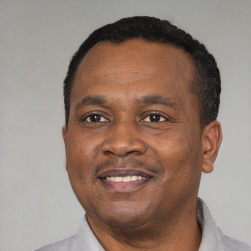 Joyful black adult male with short  black hair and brown eyes