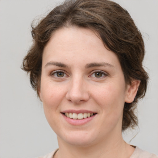 Joyful white young-adult female with medium  brown hair and green eyes