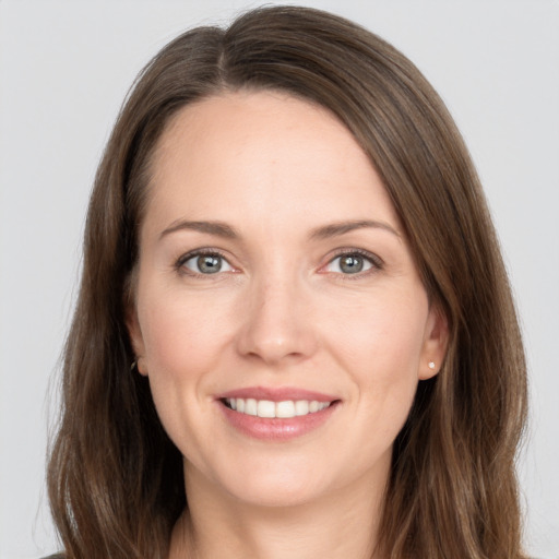 Joyful white young-adult female with long  brown hair and grey eyes