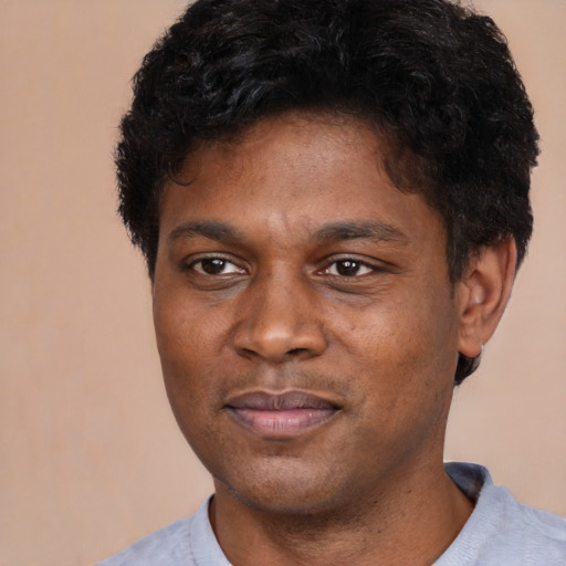 Joyful latino young-adult male with short  brown hair and brown eyes