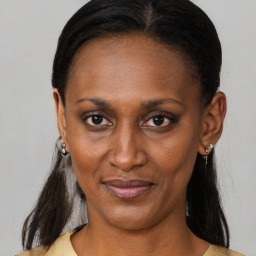 Joyful black adult female with medium  brown hair and brown eyes