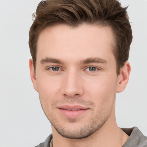 Joyful white young-adult male with short  brown hair and grey eyes