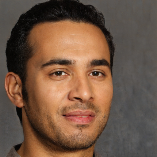 Joyful latino young-adult male with short  black hair and brown eyes