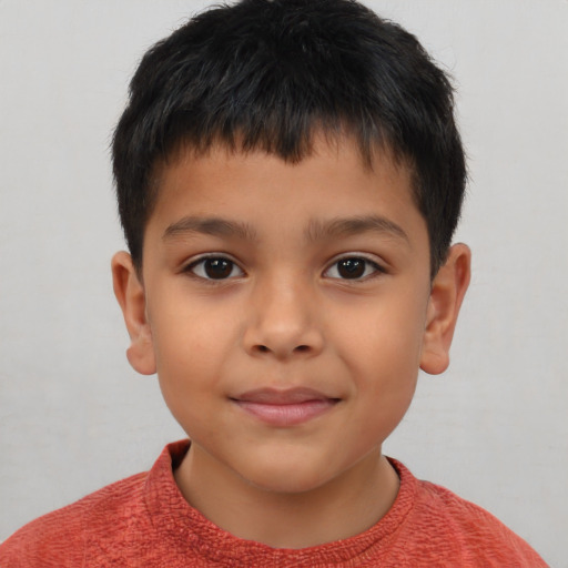 Joyful latino child male with short  brown hair and brown eyes