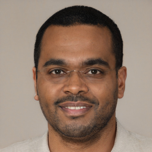 Joyful black young-adult male with short  black hair and brown eyes