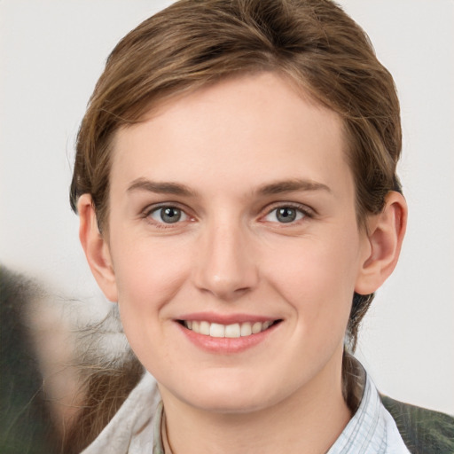 Joyful white young-adult female with medium  brown hair and grey eyes