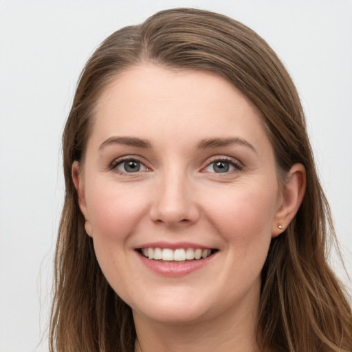 Joyful white young-adult female with long  brown hair and grey eyes